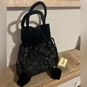 Vintage Tan’s black velvet drawstring pouch bag with a white abstract pattern.